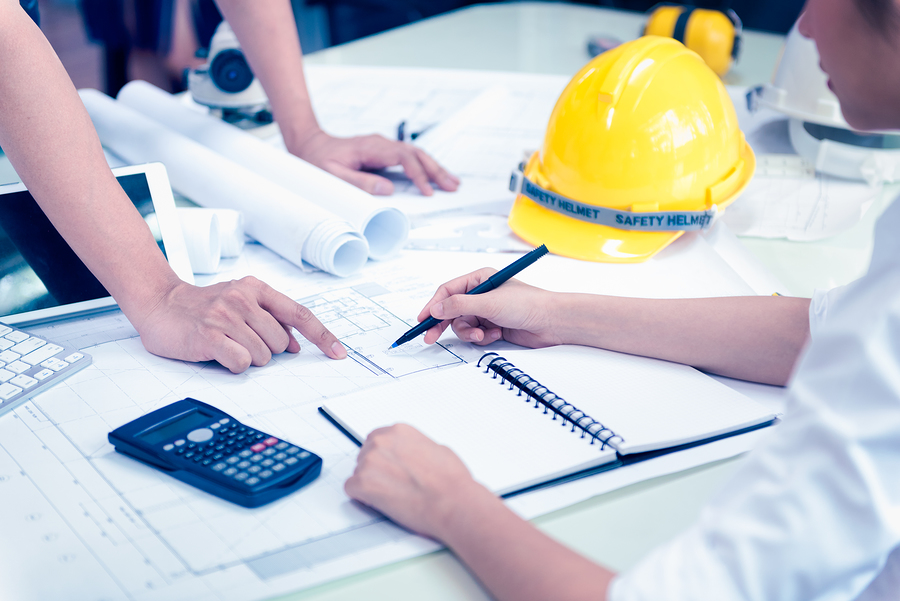 Two construction workers looking over building plans.