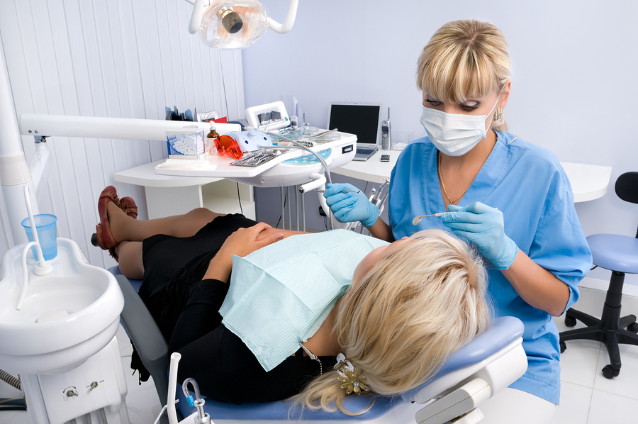 Dental assistant with a patient in a treatment room.