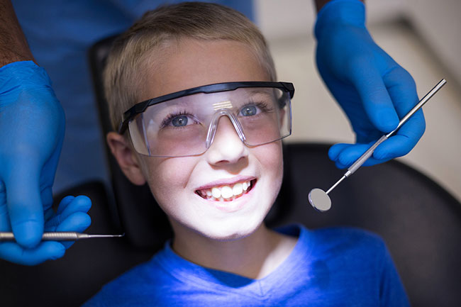 Dental professional performing procedure on boy