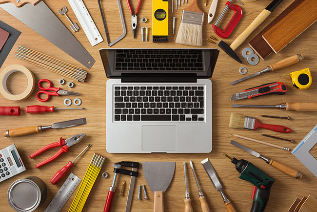 laptop surrounded by many tools