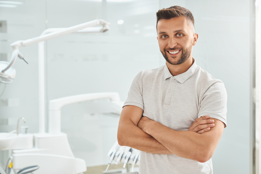 Smiling dentist in a dental office treatment room.