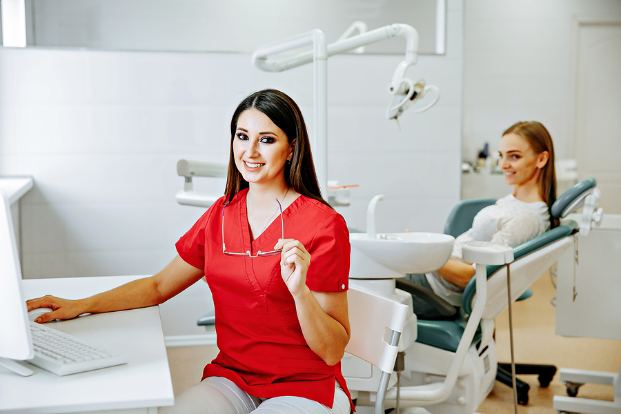 Dentist and patient in a clean modern dental treatment room.