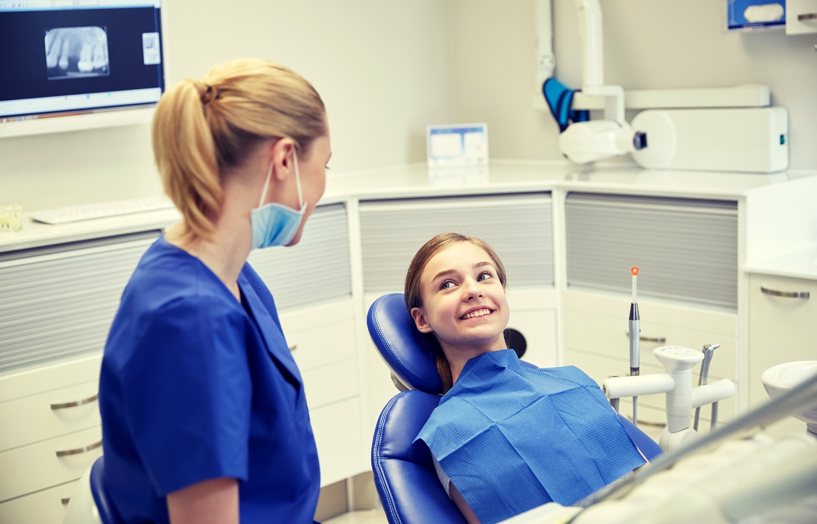 Dental professional and smiling girl