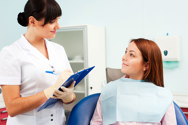 dental professional taking notes from patient in luxurious dental office